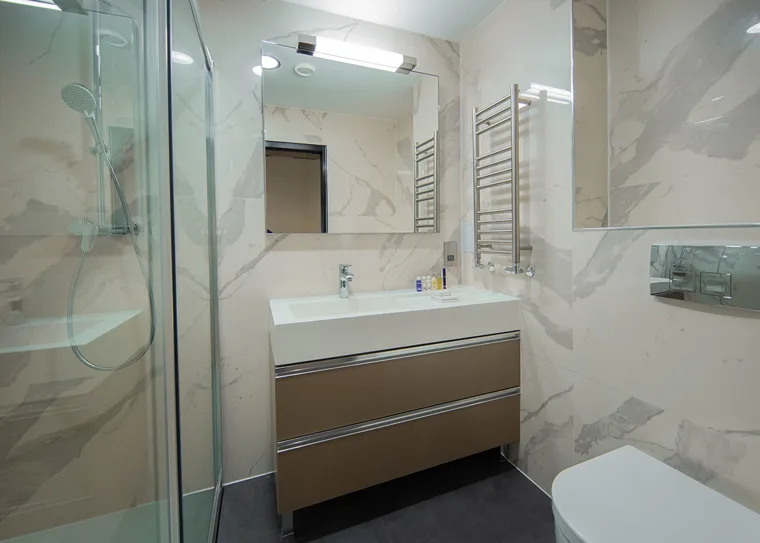 Tiled private bathroom with a shower and vanity basin
