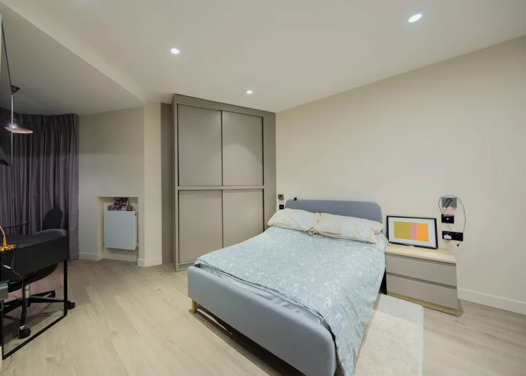 A furnished studio with a double bed and fitted wardrobe